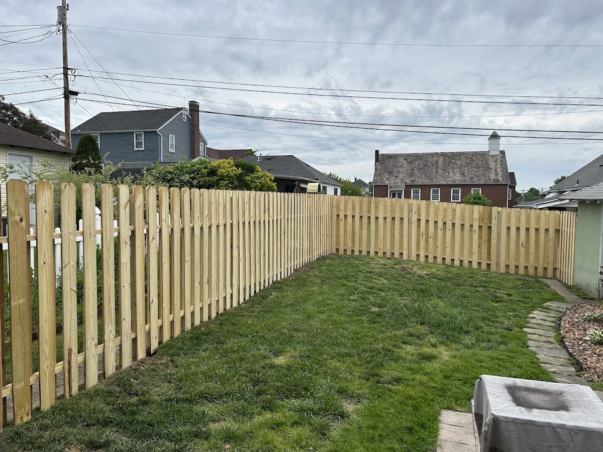 Full wood shadowbox picket fence enclosing a backyard
